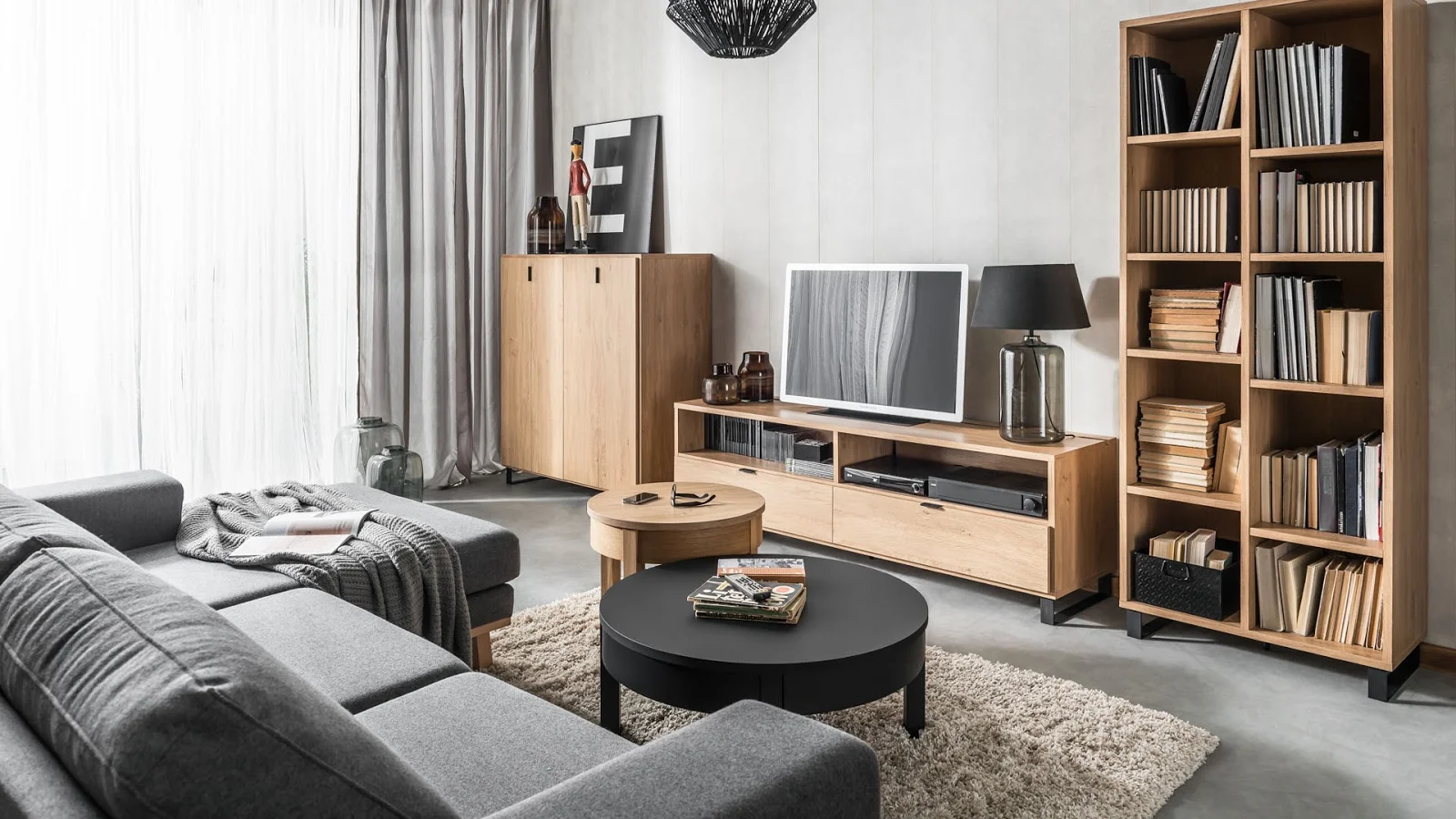 Stylowy salon z drewnianymi akcentami, dużą sofą i telewizorem.
